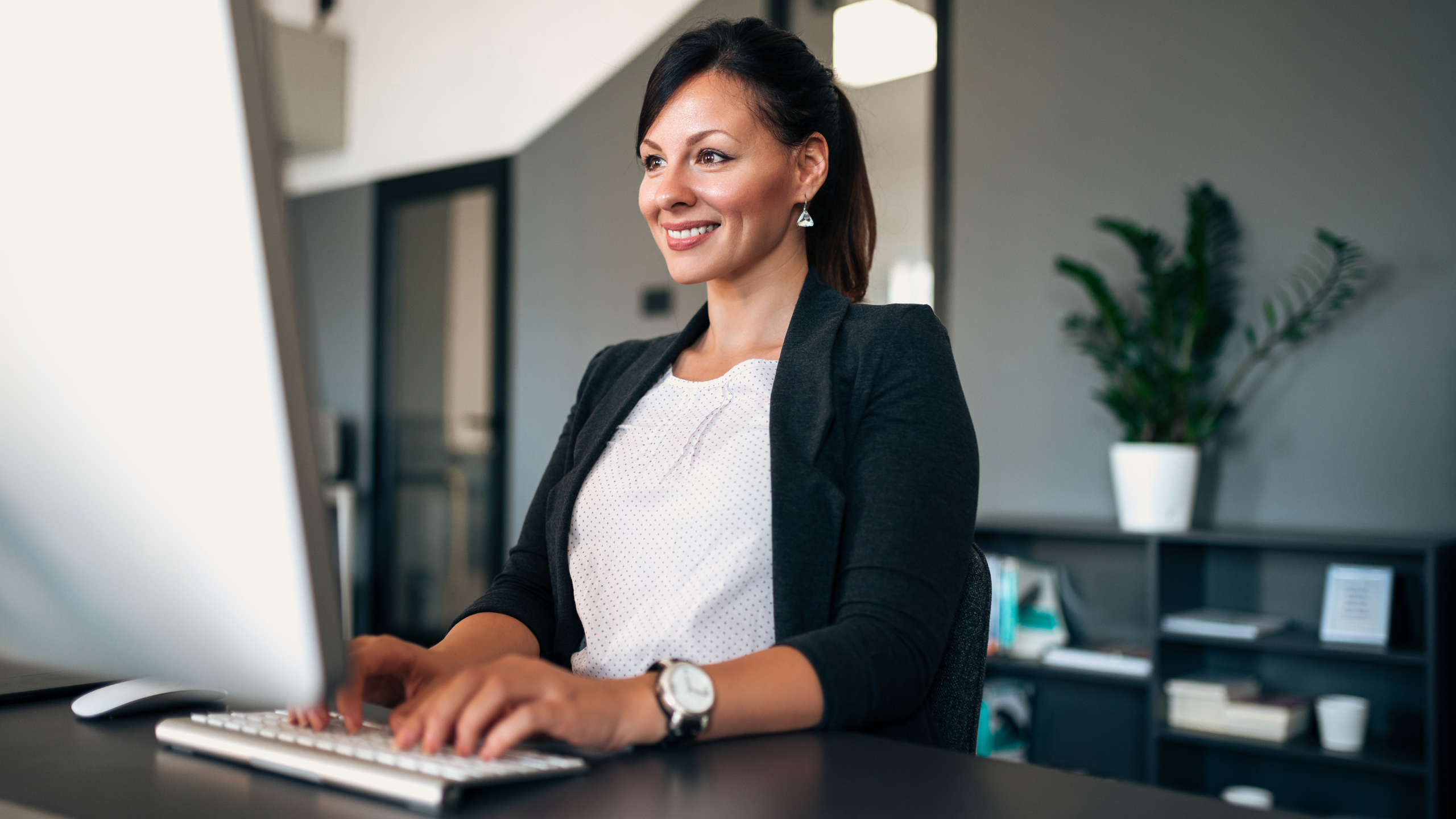 Administrative staff member working on computer at front desk