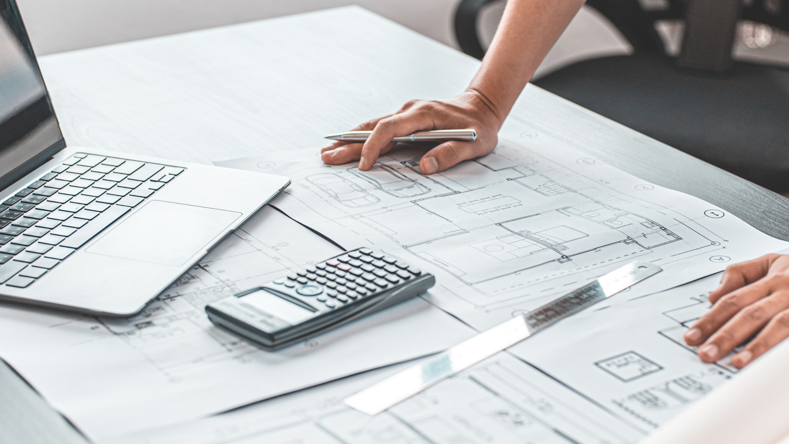 Engineering worker with hands planted on blueprints