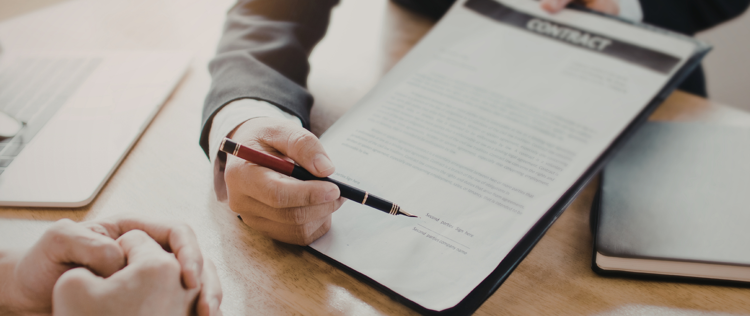 Man holding pen up to contract-to-hire staffing contract