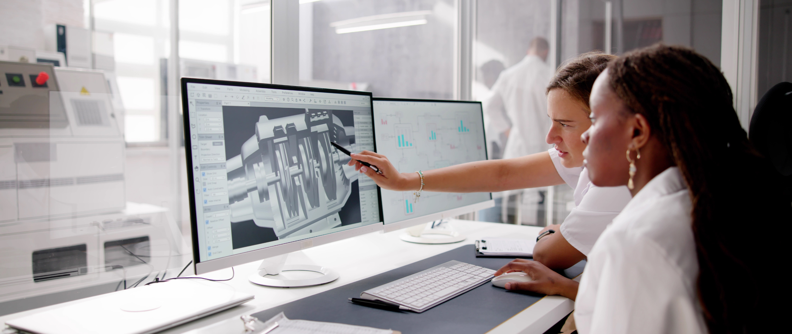 Woman pointing to computer CAD drawing while other woman works on computer for gig economy staffing