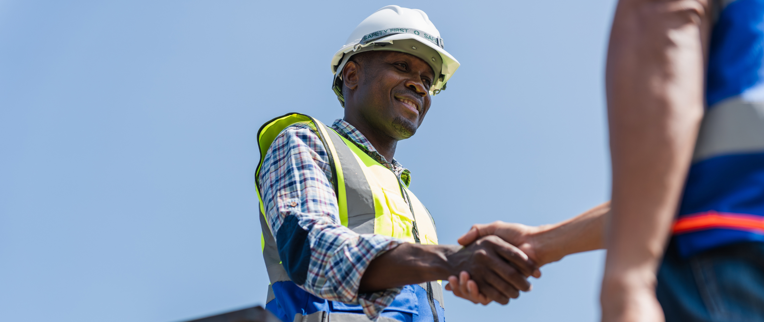 Construction worker shaking hands with person who hired him for staff augmentation