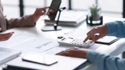 Banking compliance contractor type on calculator at desk