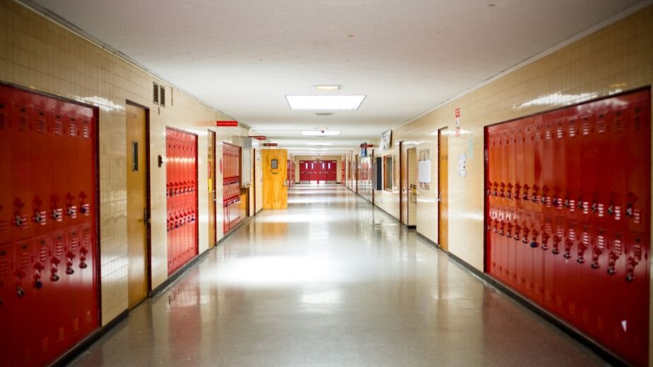 Empty school hallway with red lockers waiting for seasonal contract work to begin