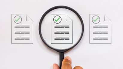 Magnifying glass hovering over compliance risk document for CHIPS, IRA, IIJA projects
