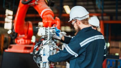 Man working on robotic arm to help with advanced manufacturing and automation setup